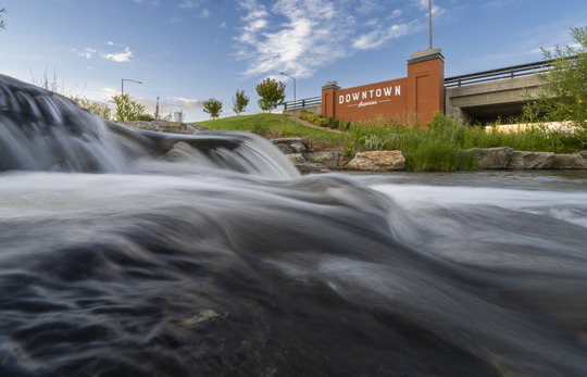 Coal creek with flowing water and the Downtown Superior bridge behind it.
