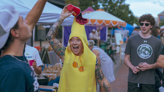 A woman in a yellow banana costume performs a magic trick