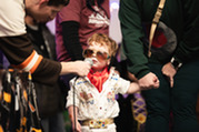 Child in a Elvis costume speaking into a microphone during Monster Mash.