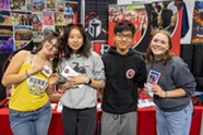 Four students pose in front of a table at the BVSD is the Place to Be Showcase
