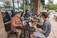 People enjoying a meal outside Wayne's BBQ.
