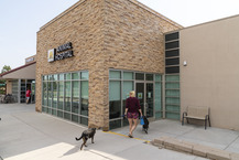 People walking their dog into Sunshine Animal Hospital.
