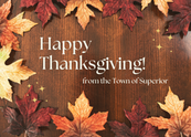 Happy Thanksgiving from the Town of Superior on brown wooden background with fall leaves