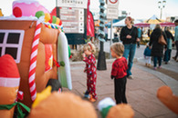 Two children peer into a holiday themed inflatable at Winter Festival