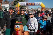 Runners pose with an inflatable turkey during Louisville's Turkey Trot