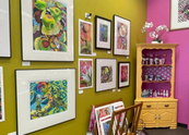 Art displayed on yellow and pink walls