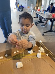A young boy plays with marshmallows and spaghetti during Stem-A-Thon 