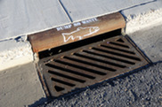 Stormwater drain marked with white painted fish and message reading "dump no waste"