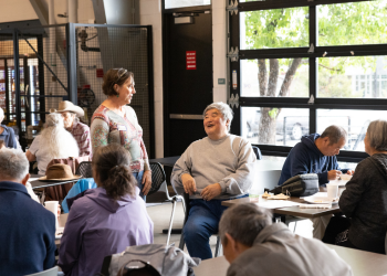Two people chat and laugh during a senior breakfast event