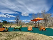 Five people at work on the Community Park Playground. They are wearing yellow shirts and are working with tools.