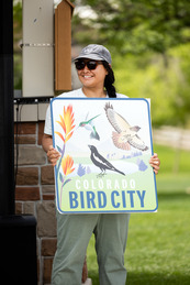 Open Space Ranger Phary Om poses with Superior's Bird City USA sign