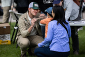 A volunteer speaks with a mother and child at an informational booth at World Migratory Bird Day