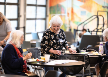 Two women chat during a senior breakfast at a round table