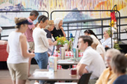 People discuss programming with contractors at tables in the Superior Community Center
