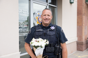 Sgt. David Salaman of the Boulder County Sheriff's Office smiles with a bouquet of flowers