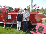 Superior Veterans Group members smile in front of Superior's red historic fire truck