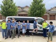 Boulder County Youth Corps members smile in front of the white work van