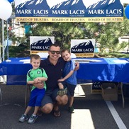 Mayor Mark Lacis and his two young children pose at a campaign booth