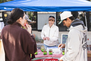 People eating produce during the Summer Market.
