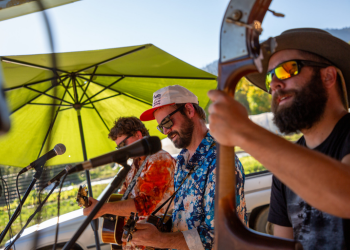 Members of a bluegrass band playing outdoors.