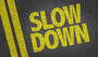 Slow down written on pavement.