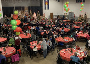 People sitting at tables at a past foster and kinship Christmas party.