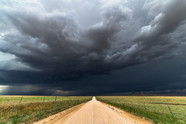 Dark skies over a dirt road.