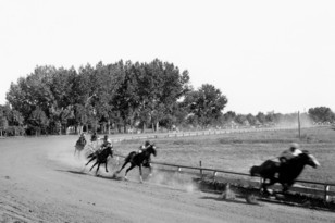 A dirt track with horses racing.