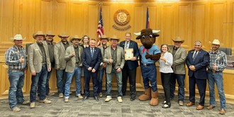 Members of the Greeley Stampede Committee standing with the Weld County Board of Commissioners.