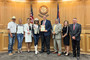 Hailey Frederiksen and her parents standing with the Weld County Board of Commissioners. 
