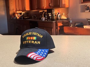 A ballcap sitting on the counter. Text reads: Disabled Vietnam veteran."