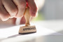 A stamp being placed on paper. Stamp says "approved."