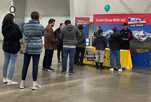 A group of kids standing at a Breeze Thru Car wash booth at last year's job fair.