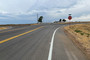 A paved road leading to a stop sign at the corner of Weld County Road 37 and 80.