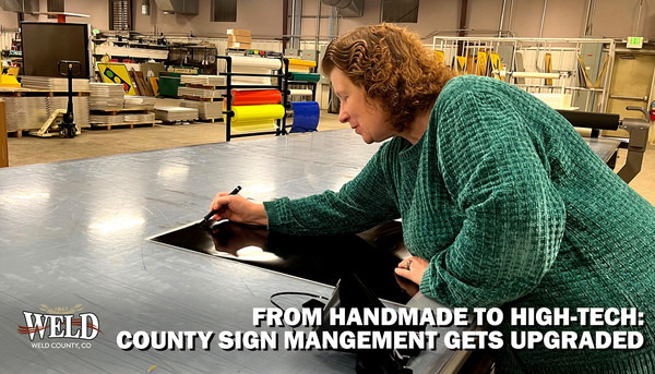Public Works sign technician Becky Turner cutting lettering for a sign. Text reads: From handmade to high-tech: County sign management gets upgraded."