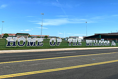 A sign outside University High School reading "Home of the Bulldogs."