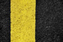 Pavement with a yellow stripe.