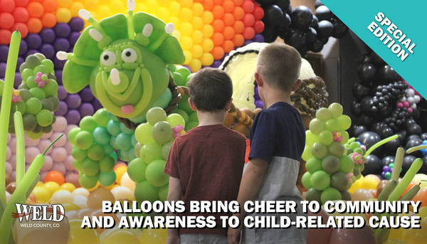 Two kids looking at a balloon display. Text reads: "Balloons bring cheer to community and awareness to child-related cause."