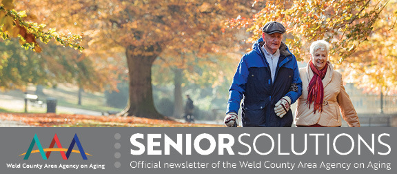 Older couple walking in autumn leaves
