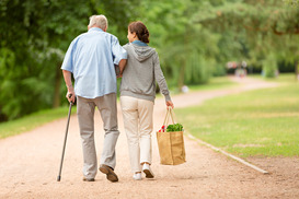elderly man walking with helper