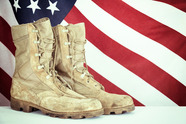 Combat boots in front of the United States Flag.