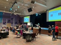 Finally Home family strengthening event, with tables of people watching a presentation.