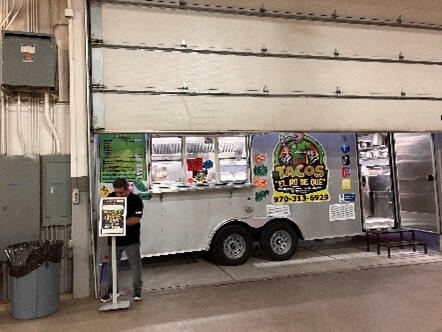 A food truck parked outside of the Christmas party, serving street tacos