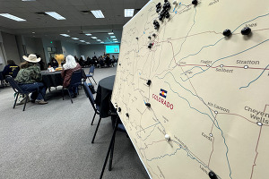 A map of Colorado with people sitting in front of it.