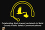 A dispatcher headset with a stork carrying a baby below. Text celebrates Stork Award recipients from Weld County Public Safety Communications.