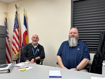 Veterans Service Officers Tim Marquart and Tom Gonzales sitting in the Weld County Veterans Service Office.
