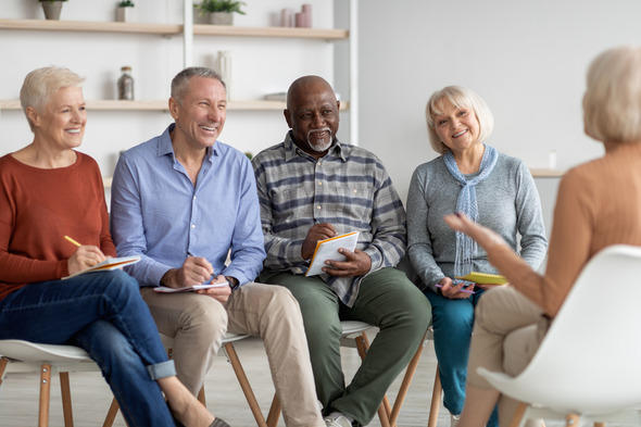 A group of older adults sitting and listening to a presenter