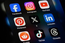 Social media icons on a cell phone screen.