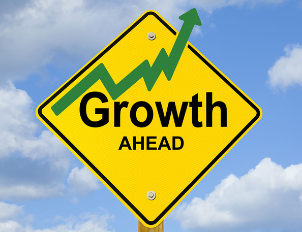 A road sign with the words "Growth Ahead" on it. A green arrow indicates growth is on the rise.