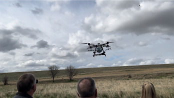 Curtis Hall, Commissioner Mike Freeman and Tina Booton watch a drone take off.